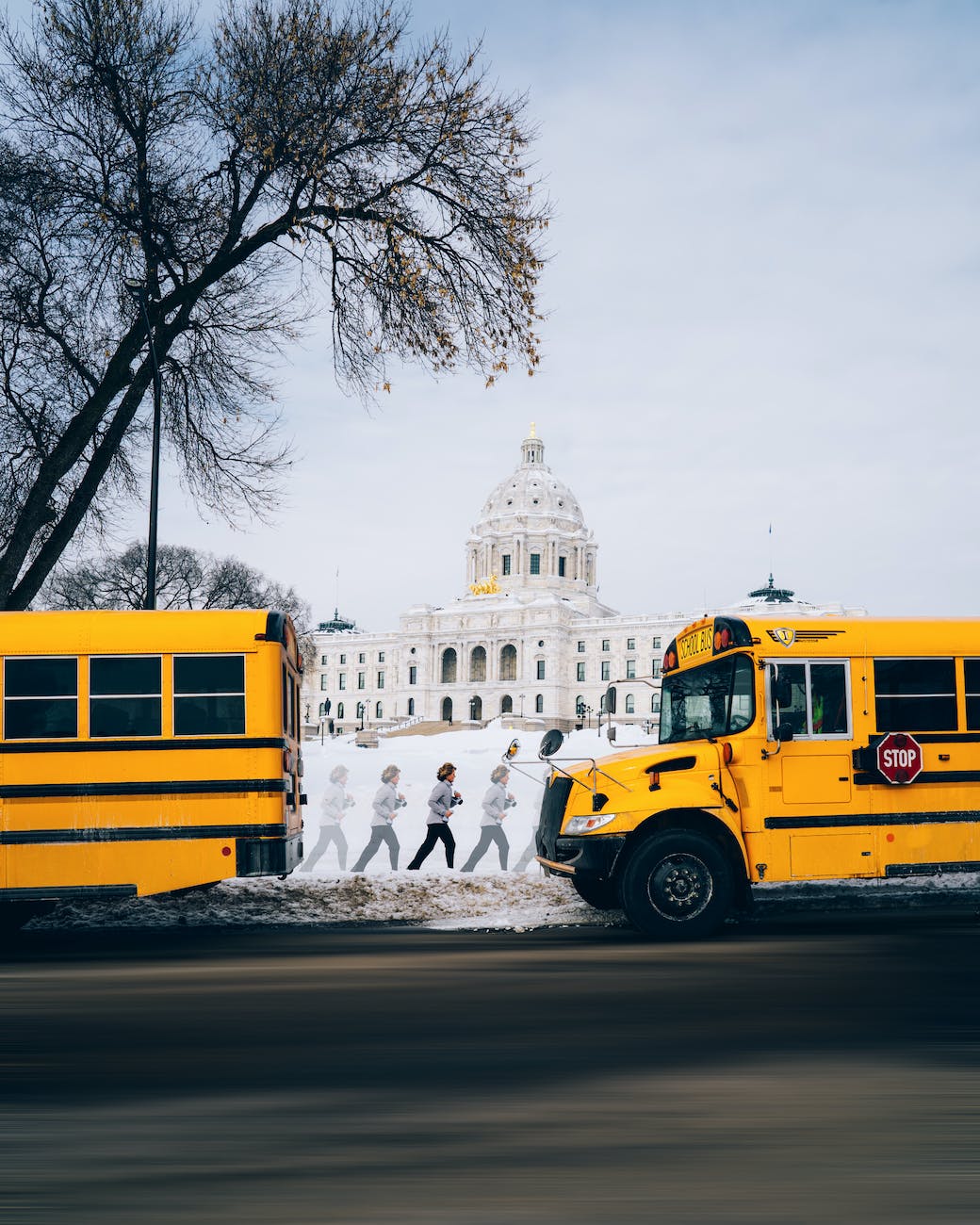 two yellow buses parked near white building