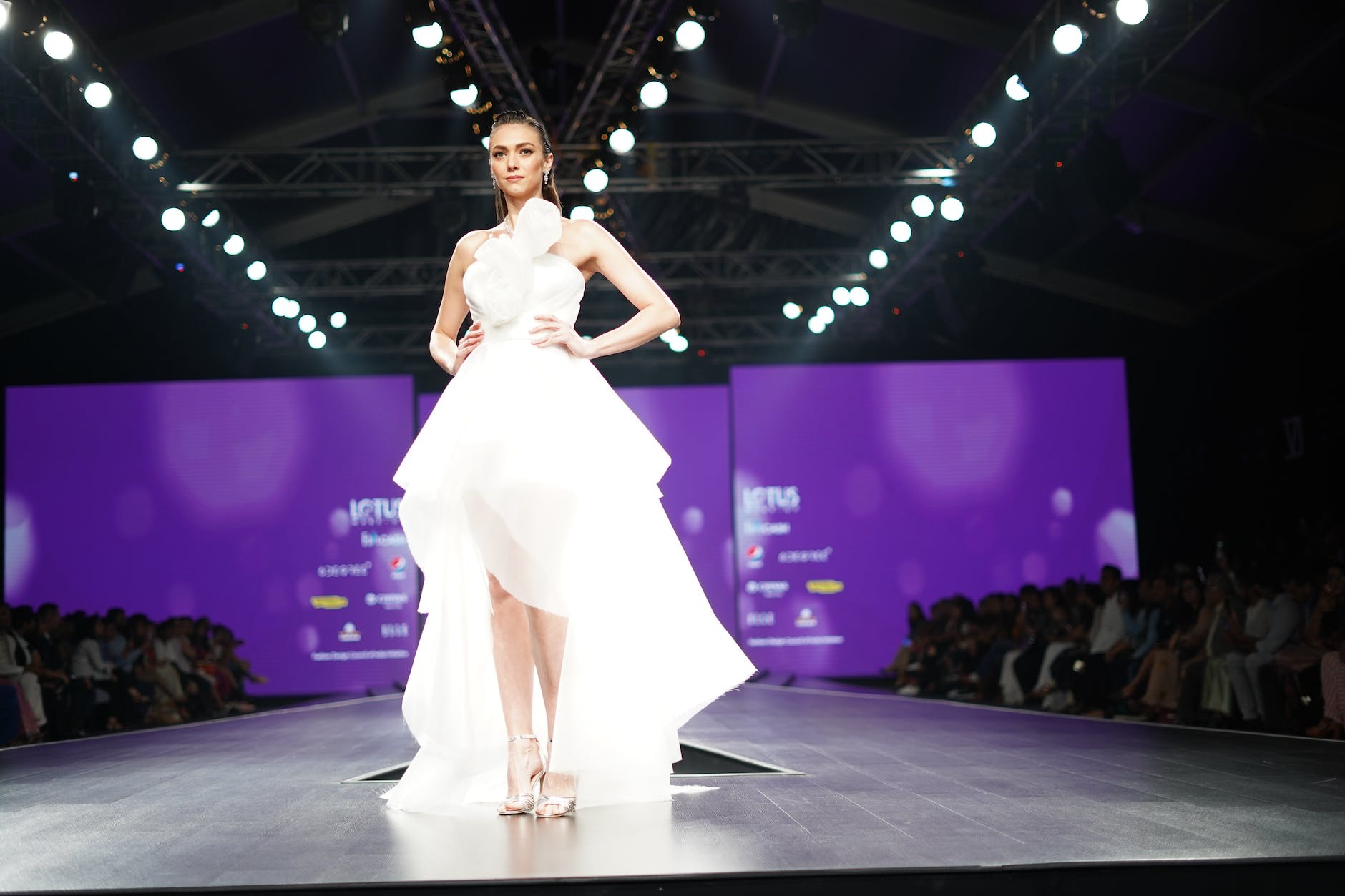 a model in a white dress on a catwalk