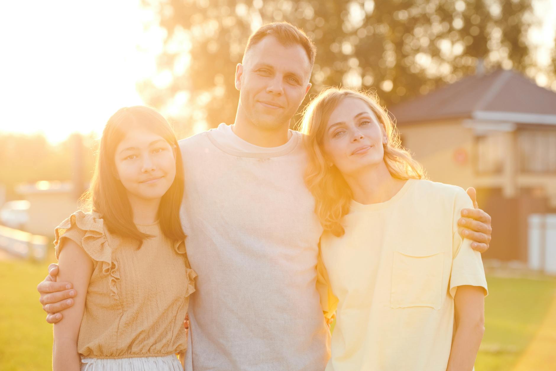 man hugging wife and daughter