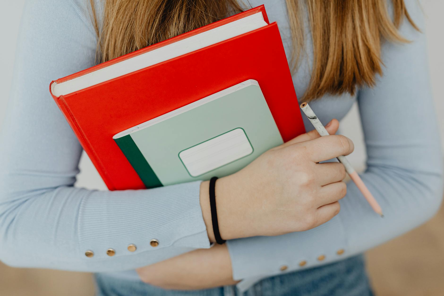 girl holding notebooks and pencil